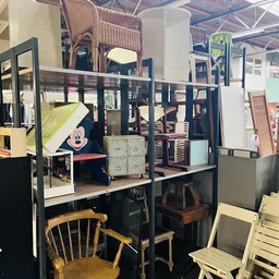 Kringloopwinkel interieur met stellingen vol meubels, stoelen en huishoudelijke spullen