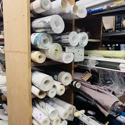 Stellingen met rollen behang en andere bouwmaterialen in de kringloopwinkel