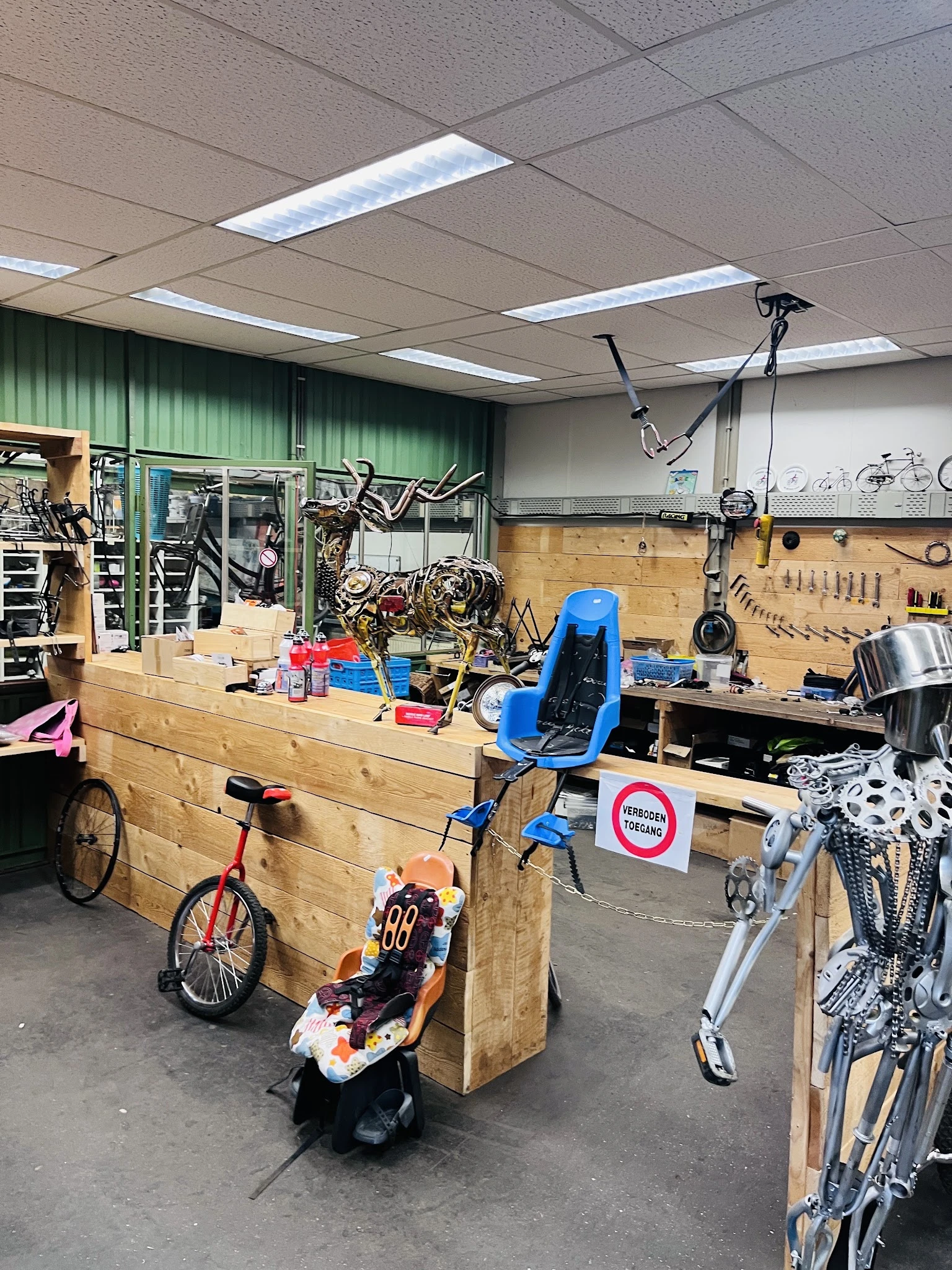 Werkplaats van fietsenreparatie met houten werkbank, gereedschapskast, hangende fietsen en reparatiemateriaal