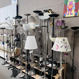 Verzameling van tweedehands lampen en verlichtingsartikelen op uitstalling, met verschillende stijlen en kleuren