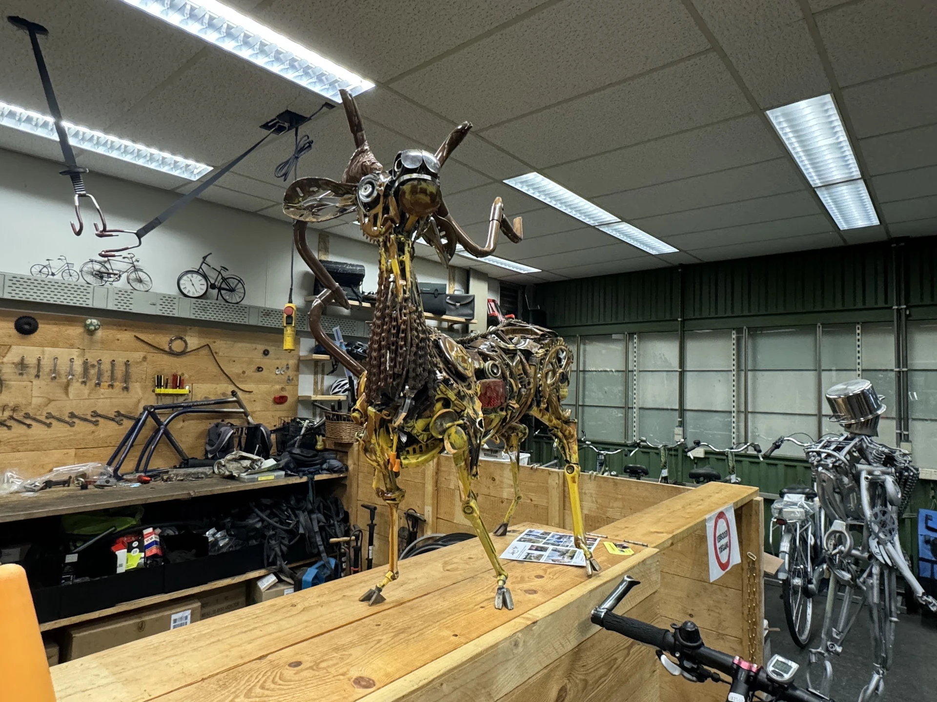 Werkplaats met een fiets in een reparatiestandaard, gereedschapsbord aan de muur en fluorescente verlichting