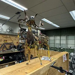 Werkplaats met een fiets in een reparatiestandaard, gereedschapsbord aan de muur en fluorescente verlichting