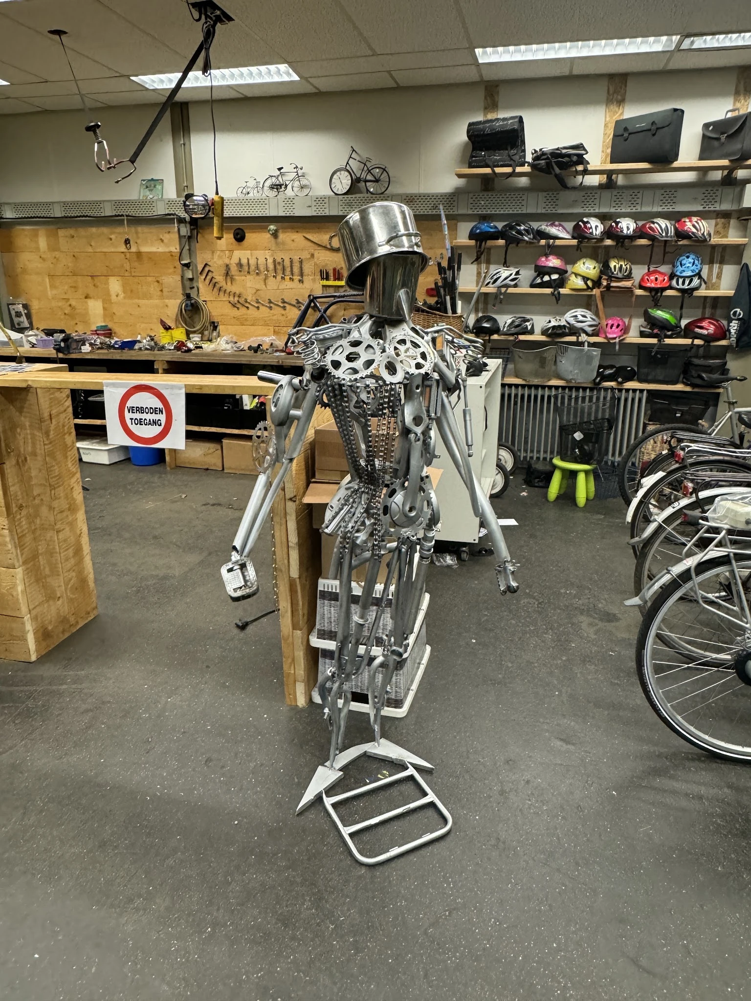 Tweedehands fiets opgespannen in een reparatiestandaard in een werkplaats, scherpgezet op het frame en de onderdelen.