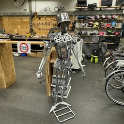 Tweedehands fiets opgespannen in een reparatiestandaard in een werkplaats, scherpgezet op het frame en de onderdelen.