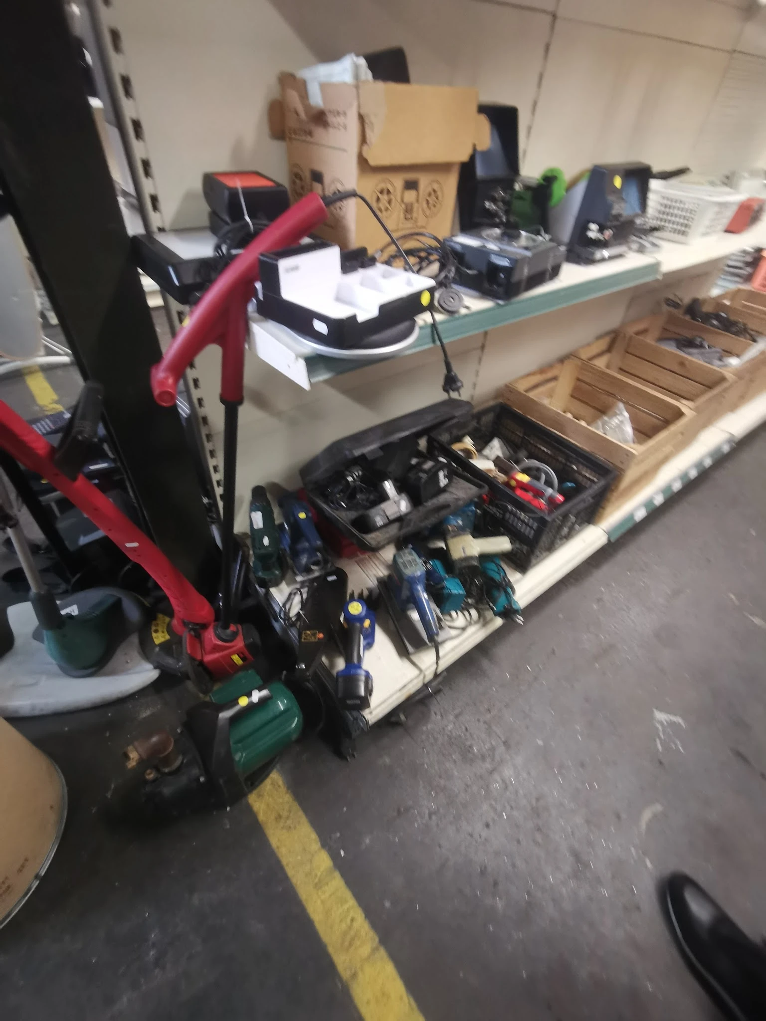 Kratten en bakken met gebruikt gereedschap en elektrische apparaten op een werktafel