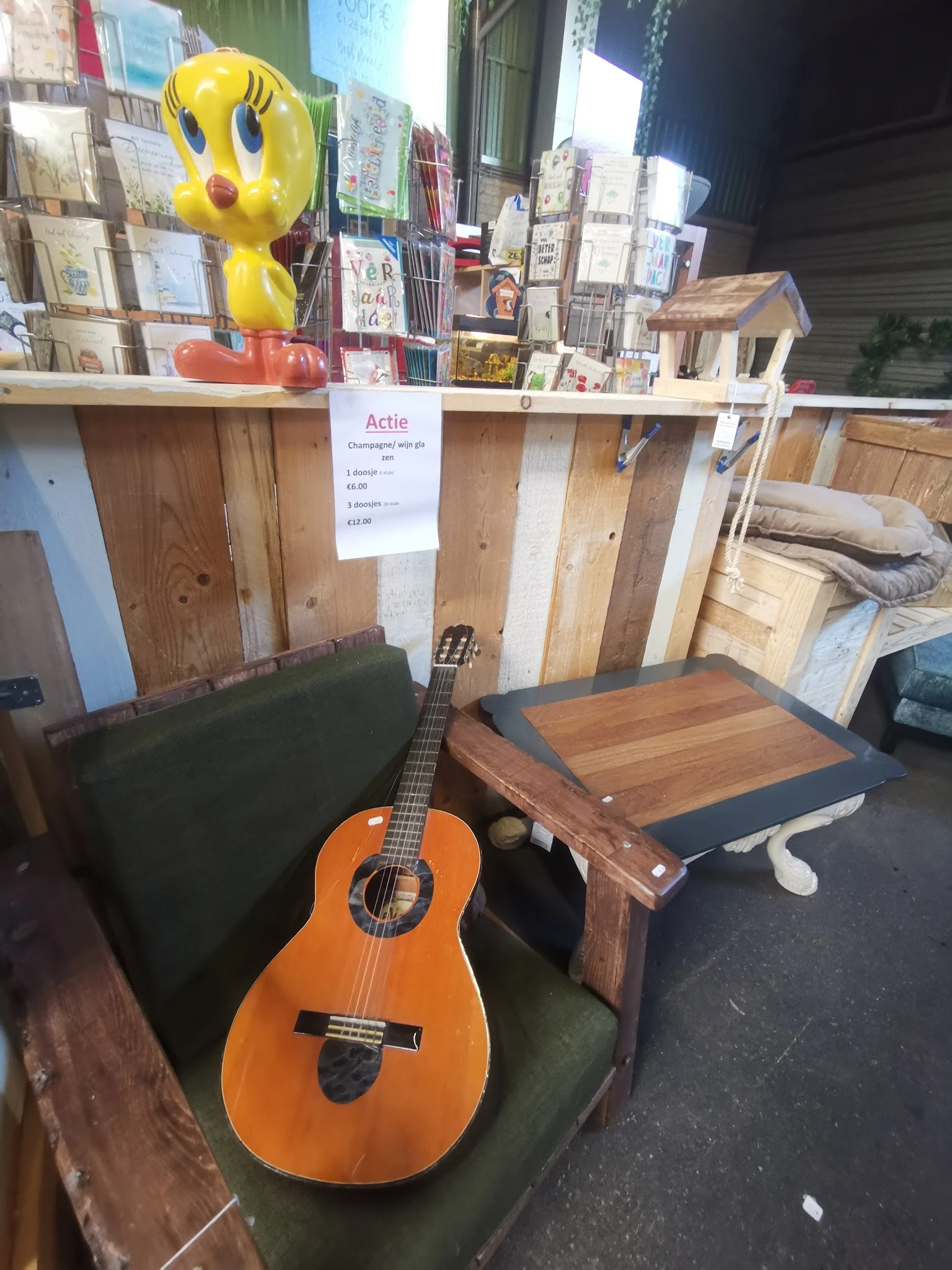 Tweedehands meubelstukken en een akoestische gitaar in de kringloopwinkel