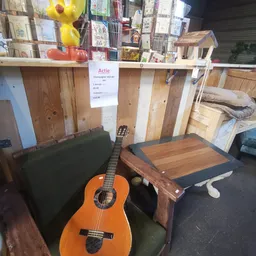 Tweedehands meubelstukken en een akoestische gitaar in de kringloopwinkel