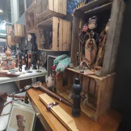 Vitrinekast met decoratieve objecten, beeldjes en handgemaakte items in een kringloopwinkel