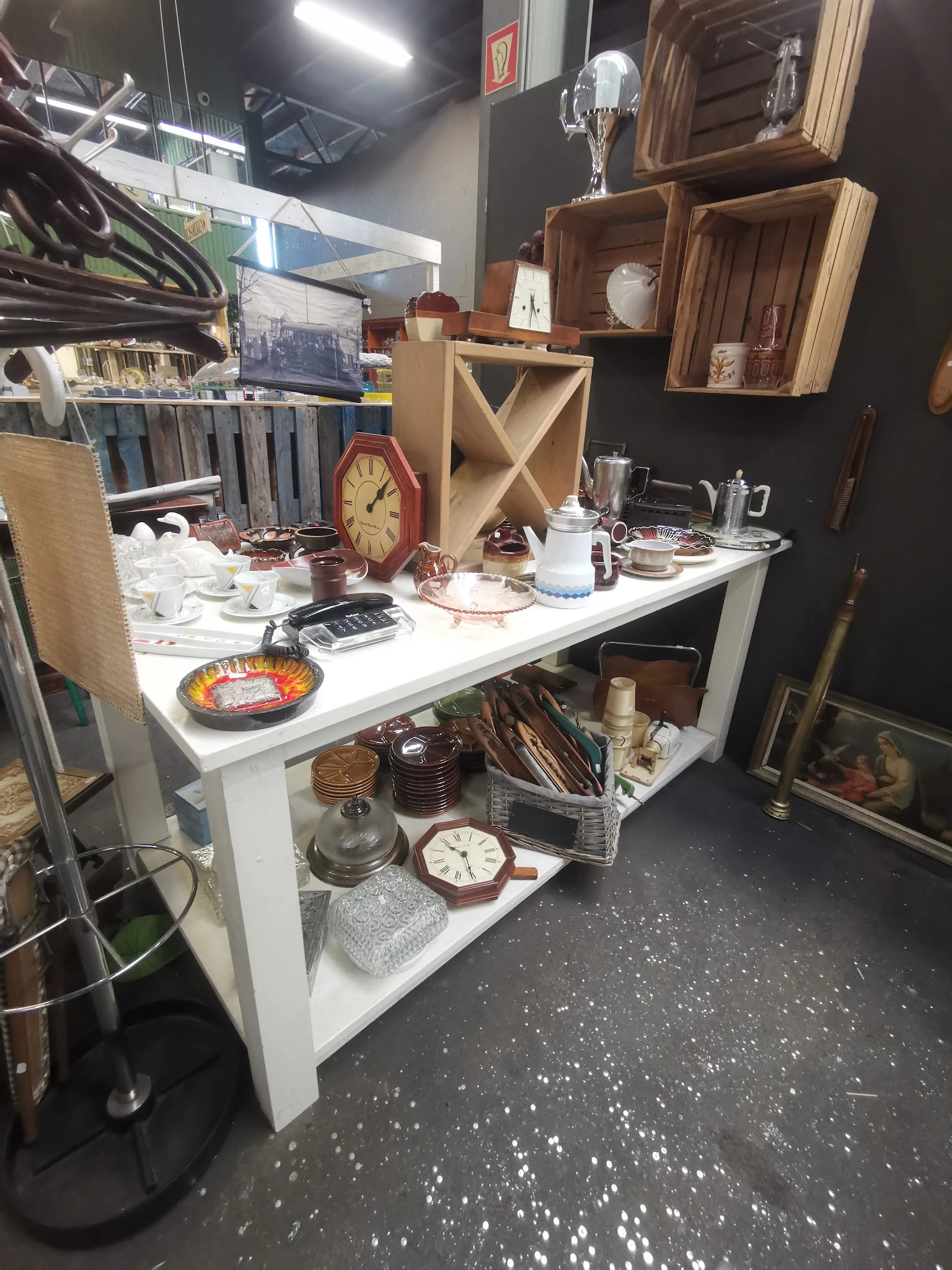 Witte display tafel met huishoudelijke artikelen: klokken, servies, glazen, kandelaars en andere decoratieve items