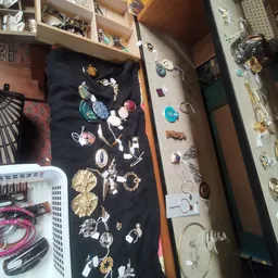 Assortiment sieraden en juwelen uitgestald op zwarte en beige doeken