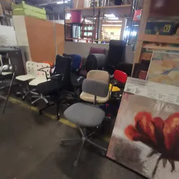 Verzameling tweedehands bureaustoel en kantoorstoelen in verschillende kleuren in de winkel
