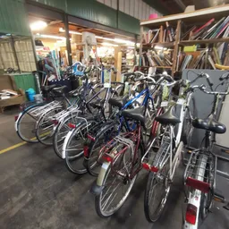 Diverse tweedehands fietsen uitgestald in de winkel, waaronder stadsfietsen en mountainbikes in verschillende kleuren