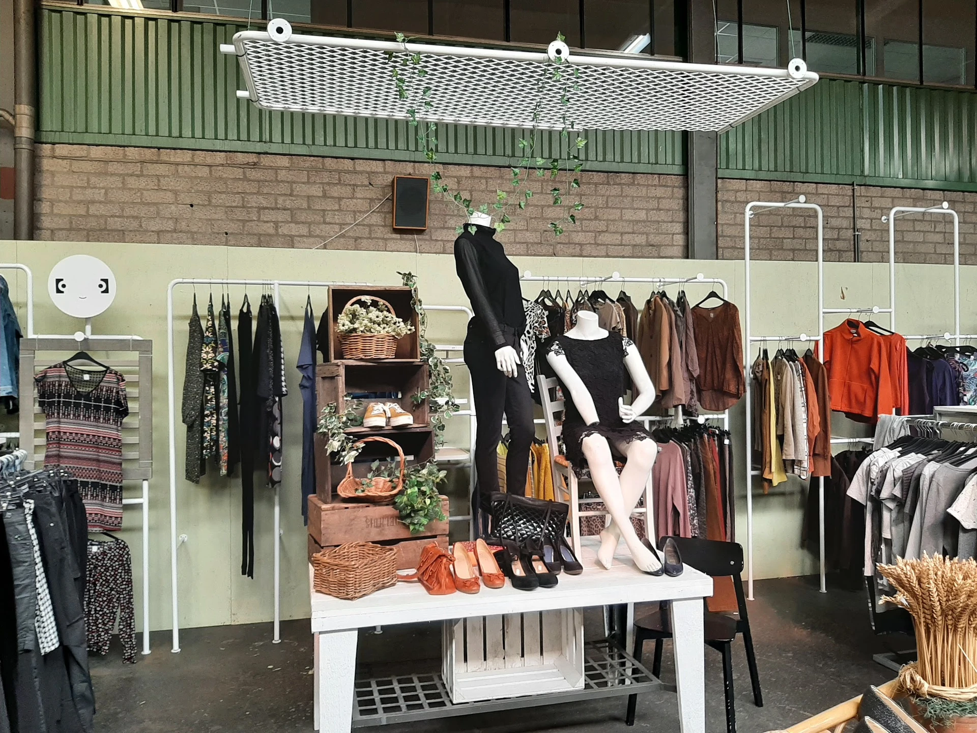 Uitstalkast met tweedehands dameskleding, accessoires en decoratie in kringloopwinkel