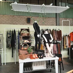 Uitstalkast met tweedehands dameskleding, accessoires en decoratie in kringloopwinkel