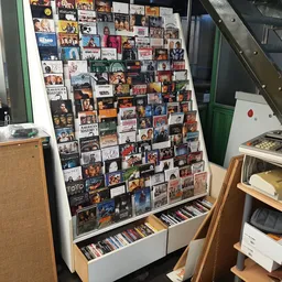 Verzameling cd's en dvd's uitgestald op en onder een prikbord met albumhoezen
