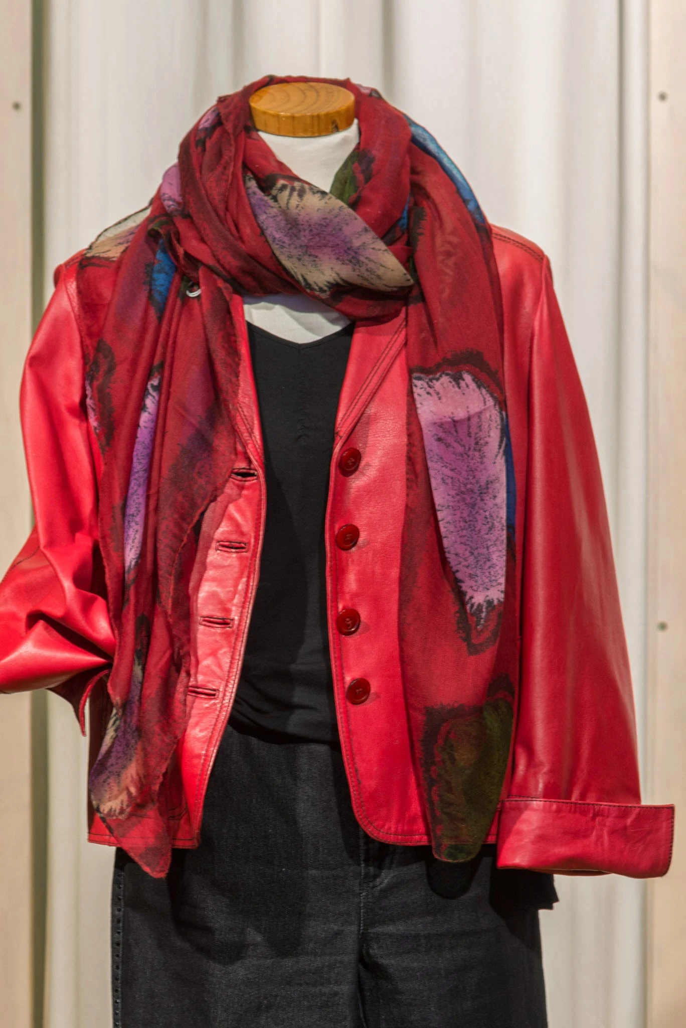 Rode vintage blazer met paarse accenten en rode knopen, uitgestald op een etalagepop