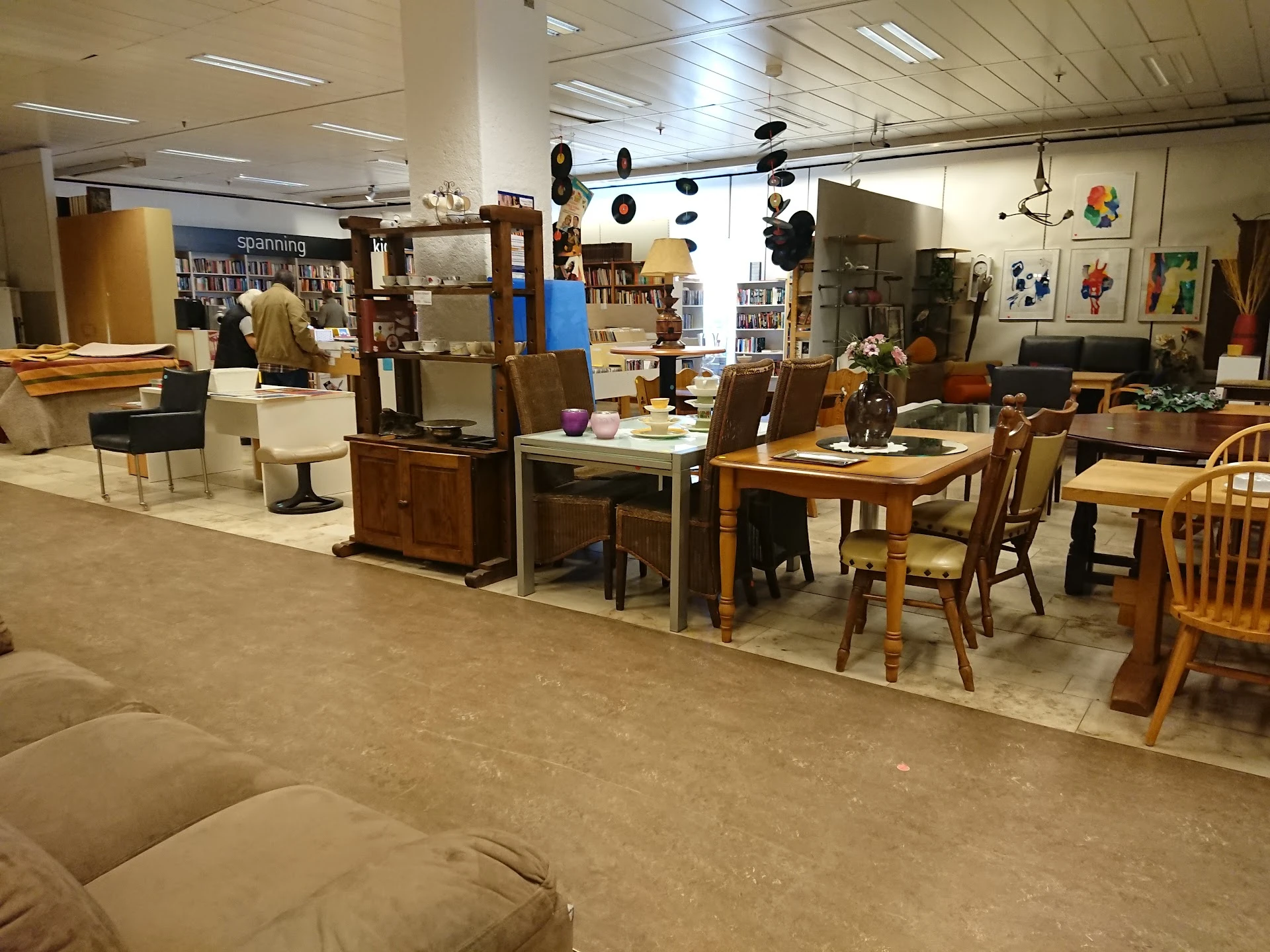 Winkelvloer met diverse meubels, tafels, stoelen en kasten uitgestald in de kringloopwinkel