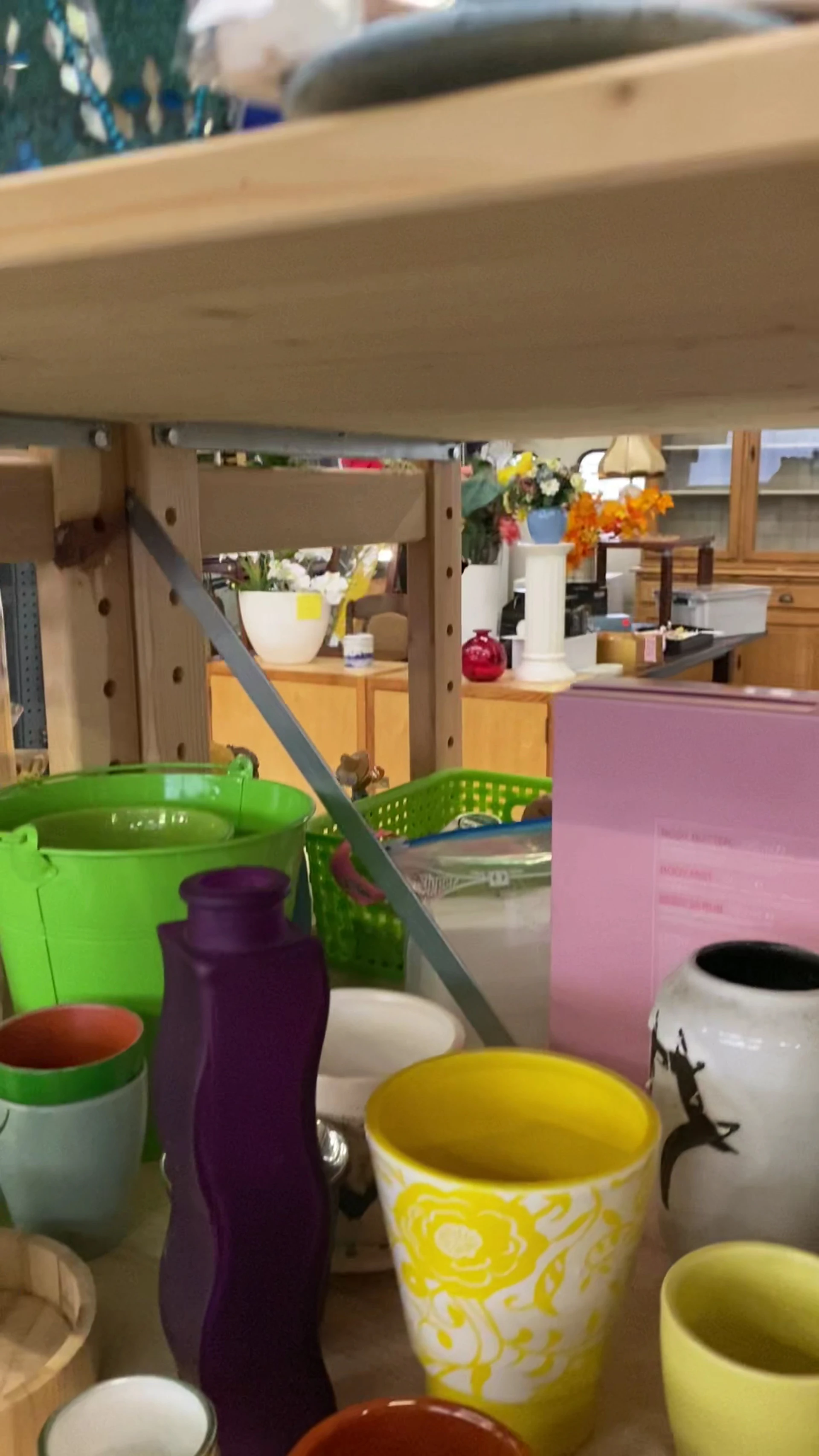 Winkelbinnenkant met gekleurde huishoudartikelen en decoraties op stellingen en toonbank