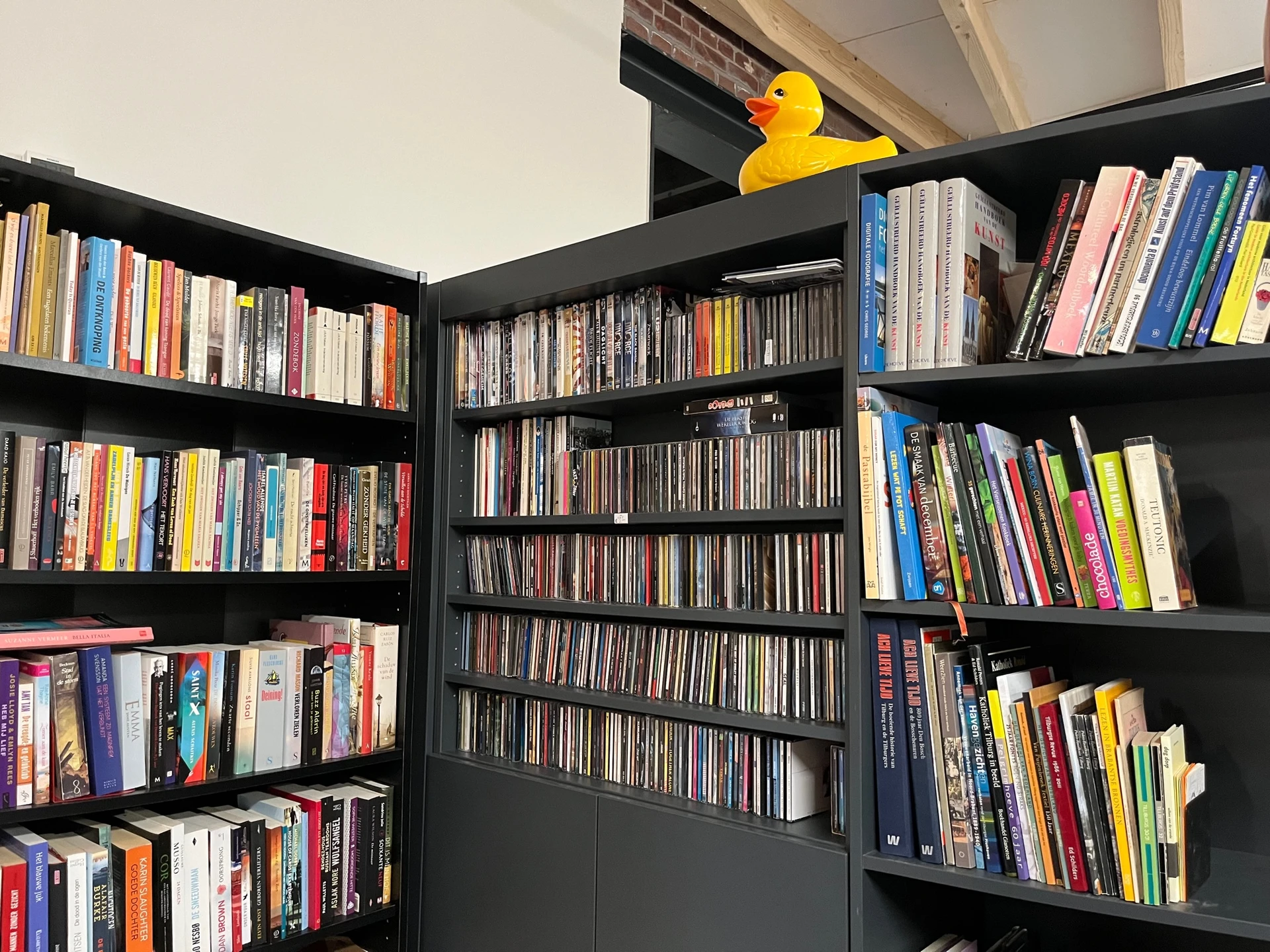 Zwarte boekenkasten vol met dvd's, cd's en boeken overzichtelijk uitgestald