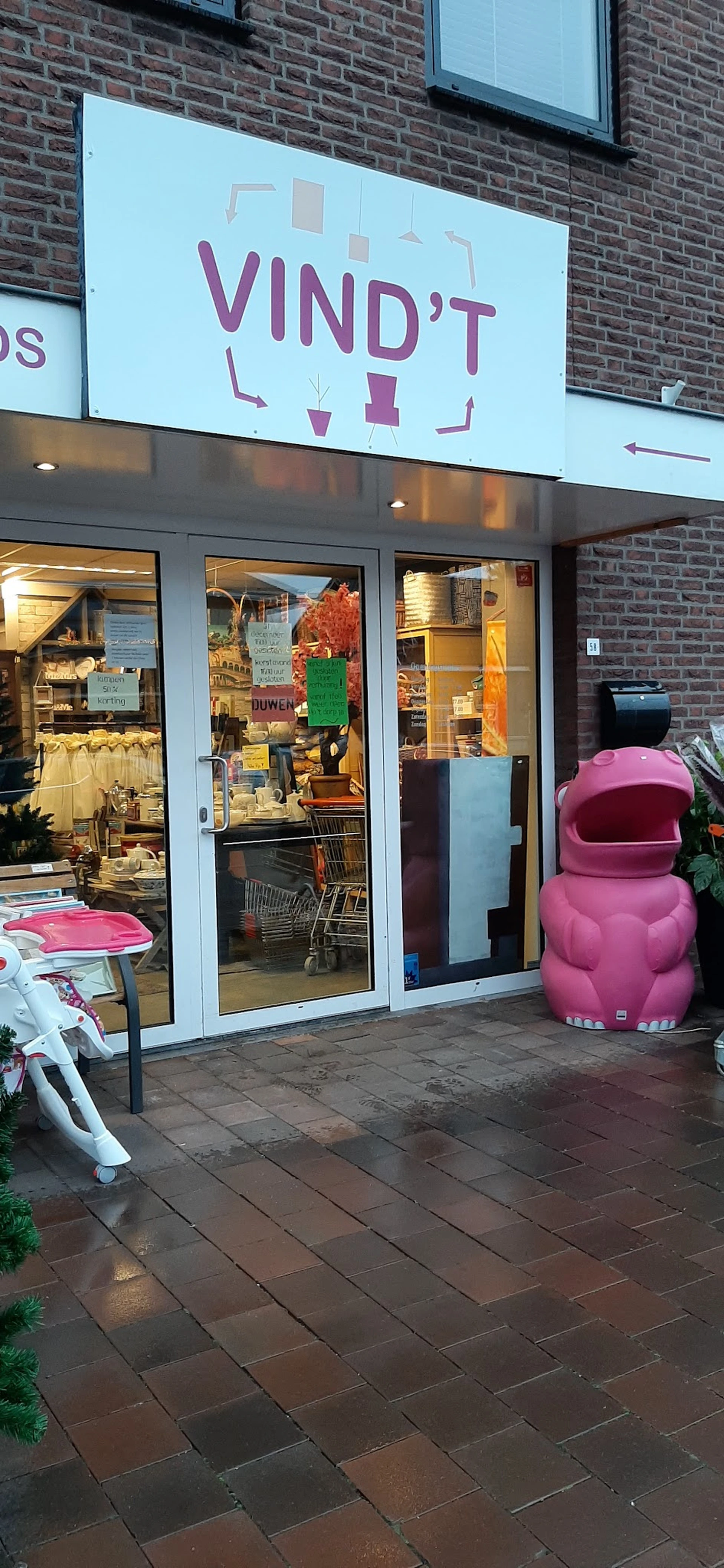 Winkelfront met glazen deuren en roze decoratieve objecten buiten