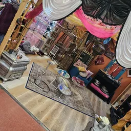 Verschillende tweedehands huishoudelijke artikelen en decoratie uitgestald op de winkelvloer