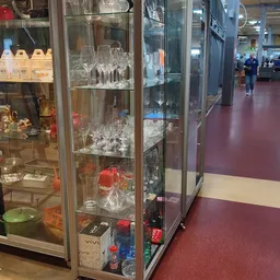 Glazen vitrinekasten met uitgestalde kristallen glazen, kandelaars en decoratieve items
