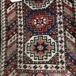 Gedetailleerde close-up van een traditioneel Perzisch of Turks tapijt met geometrische patronen in rood, blauw, wit en groen