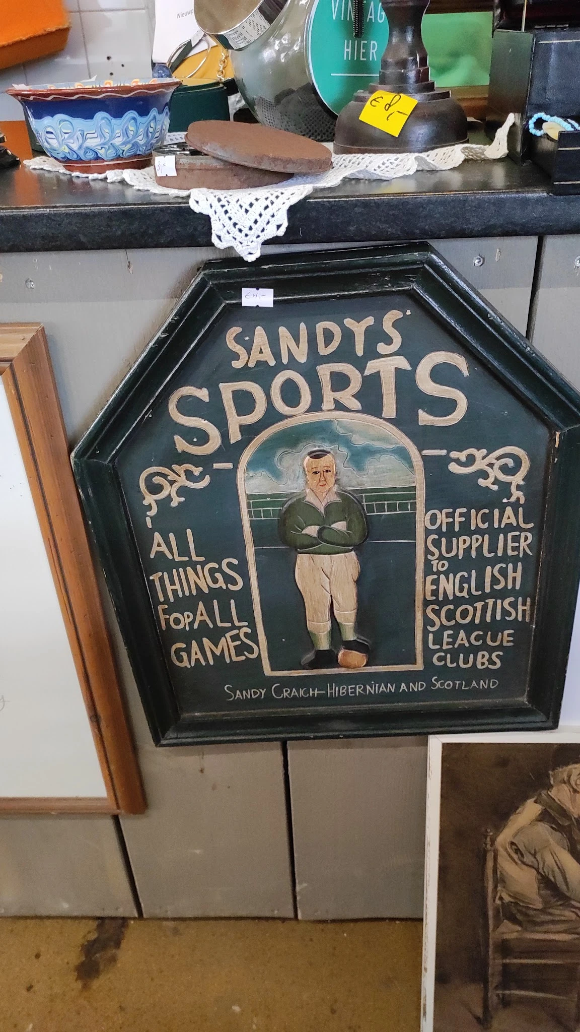 Vintage pub sign 'Sandy's Sports' met afbeelding van man in voetbalkledij, Official Supplier English Scottish League Clubs