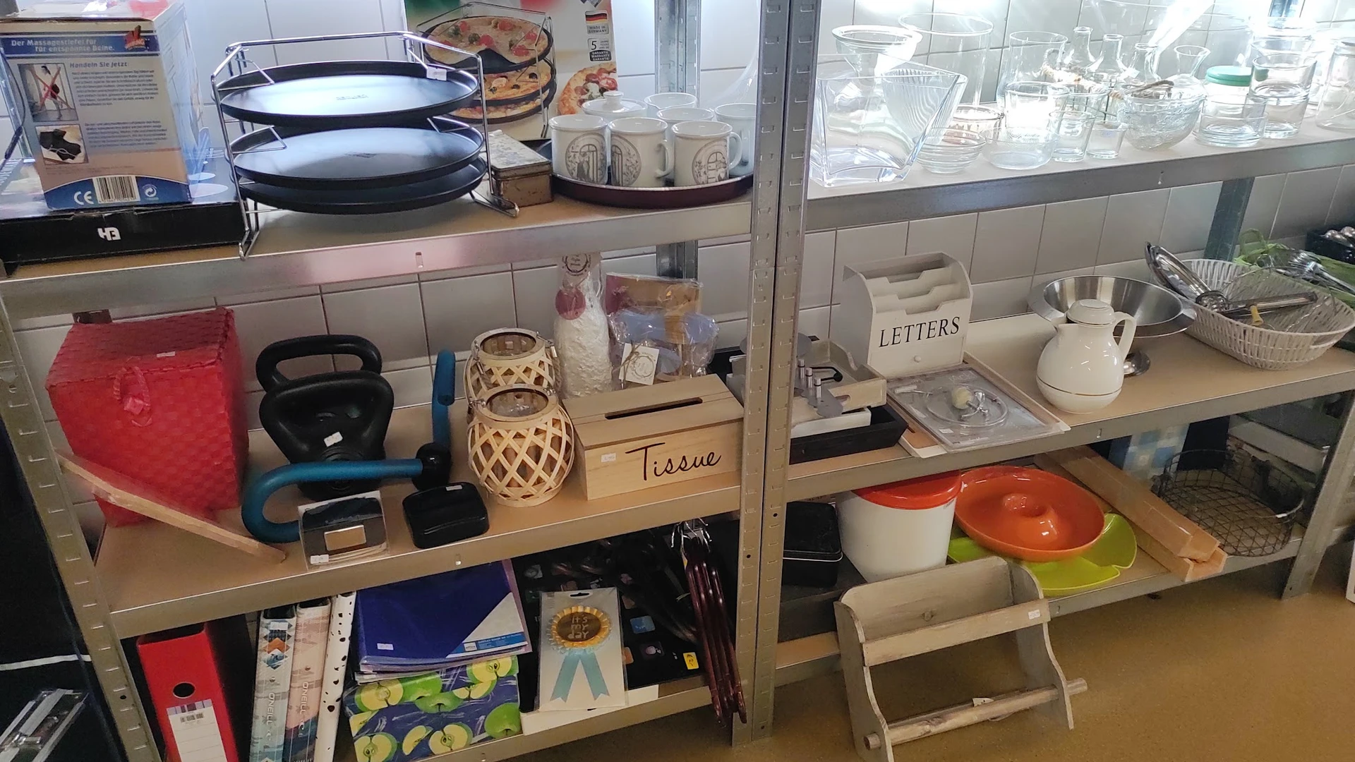 Vitrinekast met huishoudelijke artikelen: servies, lampen, tissue box en decoratieve items
