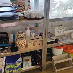 Vitrinekast met huishoudelijke artikelen: servies, lampen, tissue box en decoratieve items