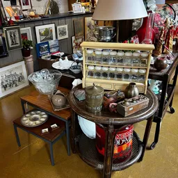 Vintage huishoudartikelen: aardewerk, glazen potten, kristallen schaal, theepotten en decoratieve items op tafels