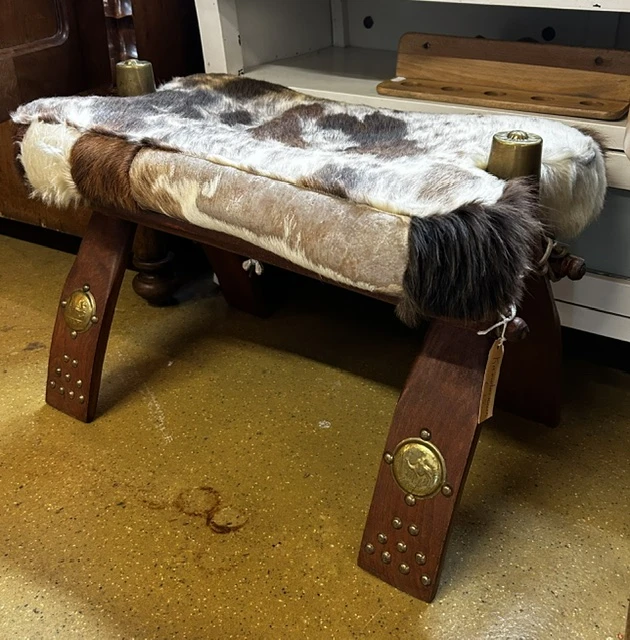 Vintage houten bank met dierenhuid bekleding en studs, close-up van meubelstuk