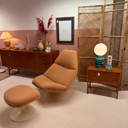 Vintage interieur met oranje fauteuil, houten dressoir, ronde lamp en decoratieve elementen