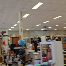 Winkelvloer met stellingen, dozen en diverse spullen in een kringloopwinkel
