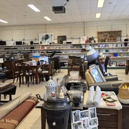 Winkelvloer met diverse meubels, huishoudelijke artikelen en decoratie op stellingen en tafels