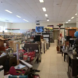 Winkelvloer met diverse meubels, kastjes en spullen verspreid door de ruimte