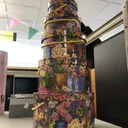 Stapel decoratieve dozen met bloemenprint en gouden banden, gestapeld als displayobject