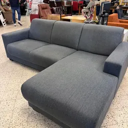 Grijze hoekbank met chaise longue in kringloopwinkel