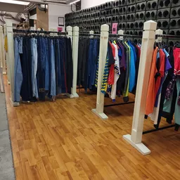 Rekken met tweedehands kleding in diverse kleuren en stijlen in de winkel