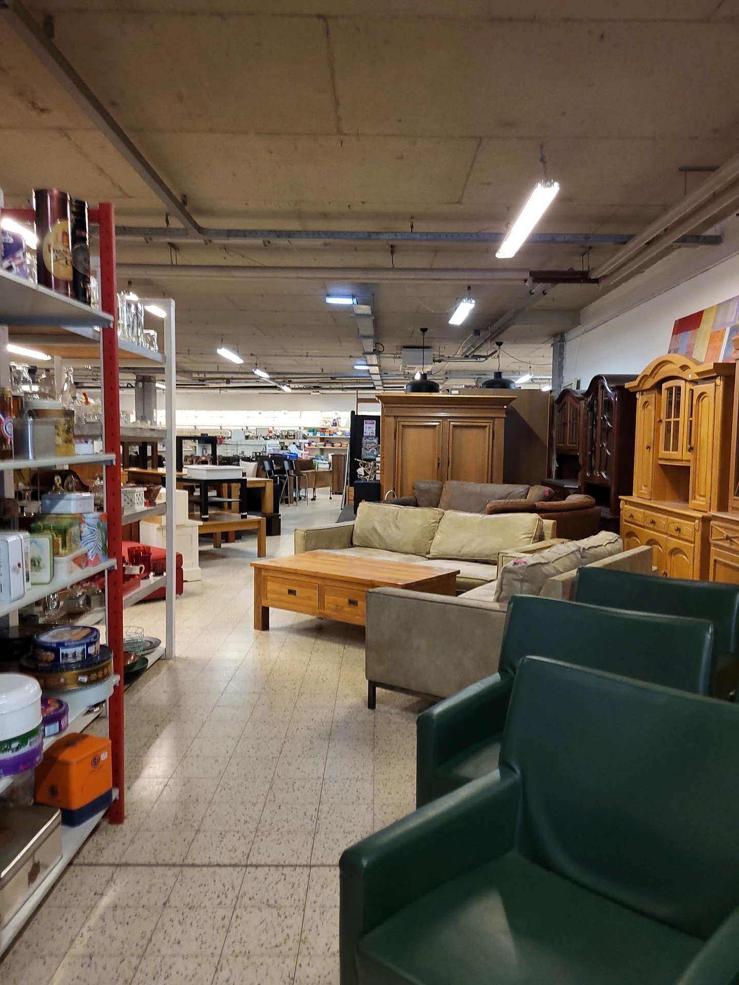 Winkelvloer met uitgestalde meubels, kasten, banken en diverse huishoudartikelen in een kringloopwinkel