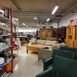 Winkelvloer met uitgestalde meubels, kasten, banken en diverse huishoudartikelen in een kringloopwinkel