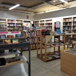Binnenaanzicht van kringloopwinkel met boekenrekken, stellingen en diverse spullen
