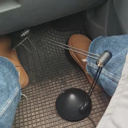 Voeten in jeans en bruine schoenen op rubberen matten in een auto