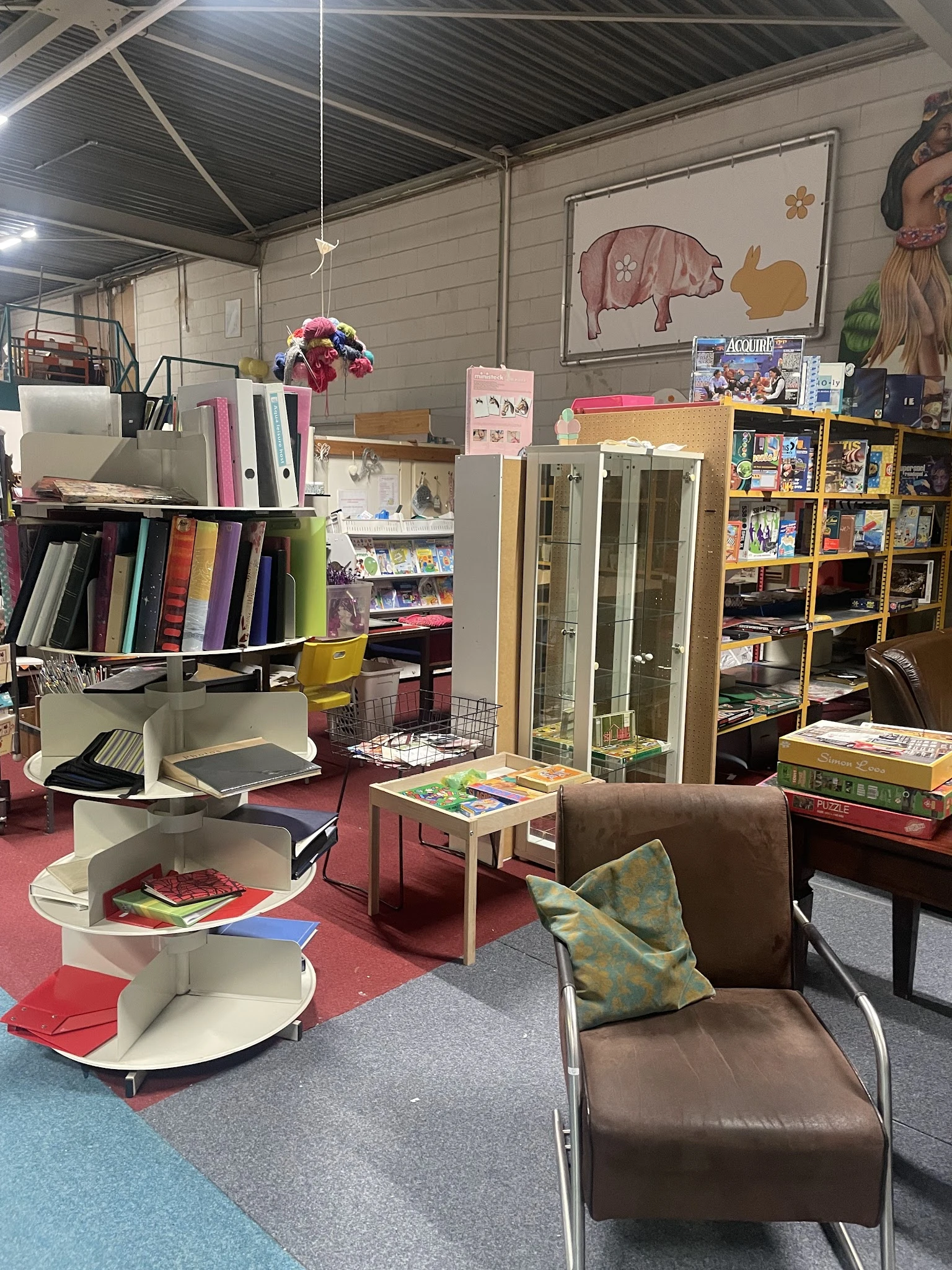 Winkelvloer met boekenrekken, kasten, fauteuil en diverse kringloopwaar uitgestald