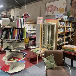 Winkelvloer met boekenrekken, kasten, fauteuil en diverse kringloopwaar uitgestald