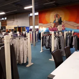 Winkelvloer met kledingrekken en decoratieve muurschildering van Hindu-godin