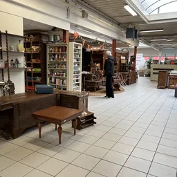 Ruim winkelinterieur met houten meubels, boeken in stellingen, decoratie en hangende ornamenten