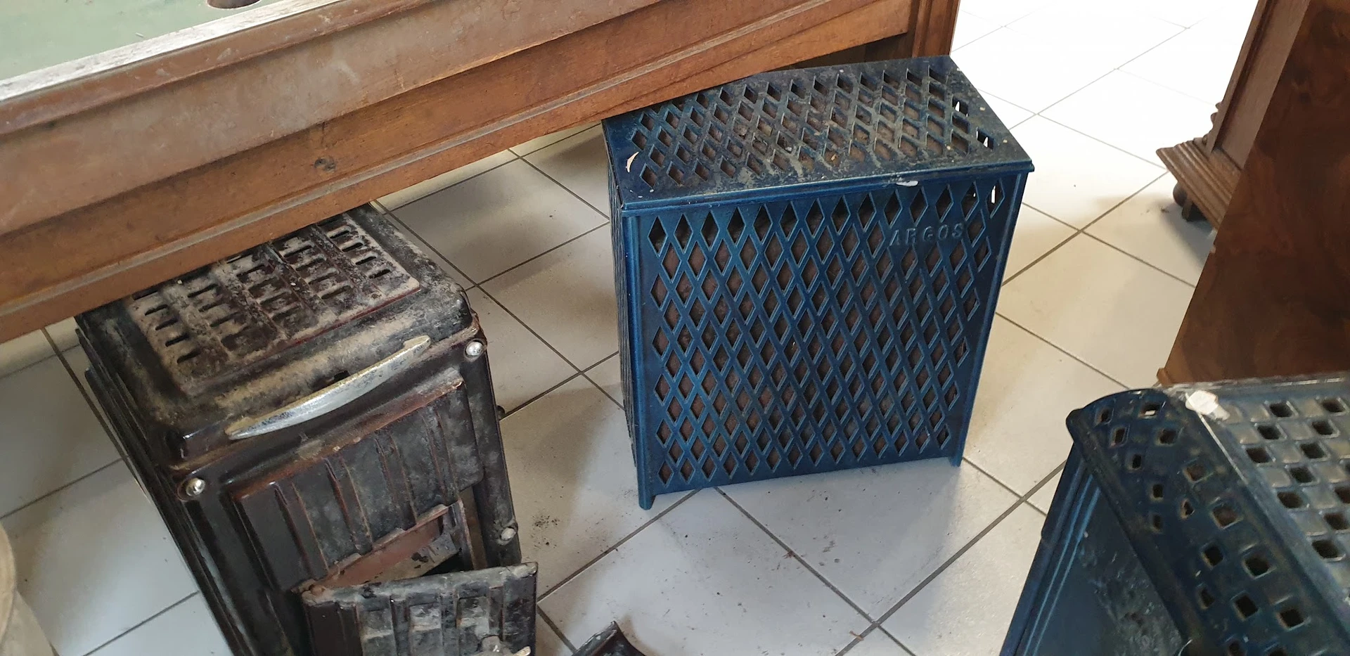 Blauwe kunststof kratten en manden op tegelvloer in winkelpand