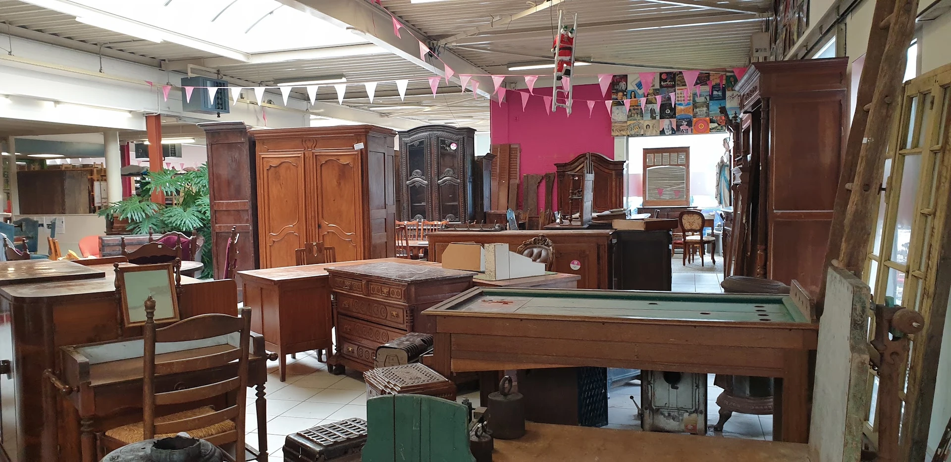 Winkelvloer met houten meubels, een pooltafel en vintage kasten in een kringloopwinkel