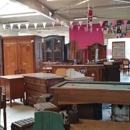 Winkelvloer met houten meubels, een pooltafel en vintage kasten in een kringloopwinkel